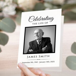 May include: Black and white photo of a man in a suit and tie, smiling. The photo is on a white card with the text "Celebrating the life of" above the photo and "James Smith" below the photo. The dates "September 9th, 1945 - January 14th, 202X" are printed below the name.