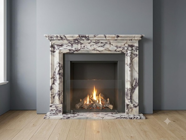Puede incluir: Una chimenea con marco de m&aacute;rmol blanco y vetas de color p&uacute;rpura oscuro. La estructura presenta una repisa rectangular y columnas verticales que enmarcan un hogar de metal negro con una pantalla de cristal y le&ntilde;os artificiales encendidos.
