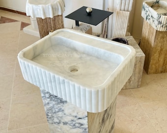 Könnte beinhalten: Ein rechteckiges Waschbecken aus weißem Marmor mit geriffeltem Außendesign und einem zentralen Abflussloch. Die Oberfläche des Beckens zeigt dezente graue Maserungen und enthält den Text STONE-CRAFT.com.tr in der Mitte der Innenseite.