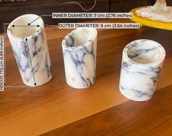 Könnte beinhalten: Drei zylindrische Behälter aus weißem Marmor mit grauer Maserung. Der größte Behälter hat eine Höhe von 17,5 cm, einen Innendurchmesser von 7 cm und einen Außendurchmesser von 9 cm, wie durch die Textbeschriftungen im Bild angegeben.