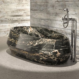 May include: A freestanding oval bathtub featuring a polished black marble finish with prominent white and gold veining. The tub has a faceted, geometric exterior design and is paired with a tall, chrome-finished floor-mounted faucet fixture.