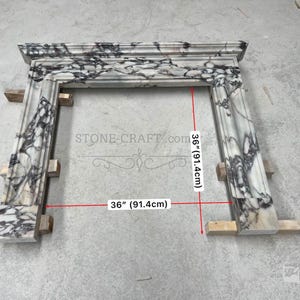 Puede incluir: Una repisa de chimenea de m&aacute;rmol blanco y negro con acabado pulido y vetas complejas. La estructura presenta un estante superior rectangular y dos pilares laterales verticales. Las l&iacute;neas de medici&oacute;n rojas indican 91,4 cm.