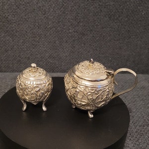 Antique silver pepper shaker and salt bowl made around 1900.