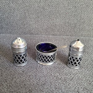 A vintage set of salt and pepper shakers and mustard dishes made in England.
