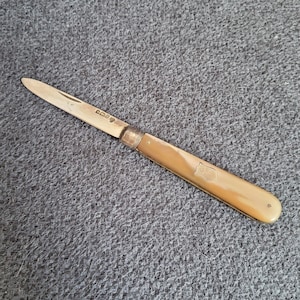 Antique folding fruit knife made of sterling silver and mother-of-pearl handle.