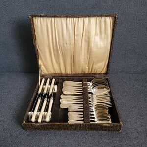 May include: A vintage silverware set in a brown leather case with a cream-colored lining. The set includes knives, forks, and spoons.
