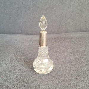 Antique crystal perfume bottle with silver collar.
