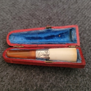Antique cigarette holder with silver details.