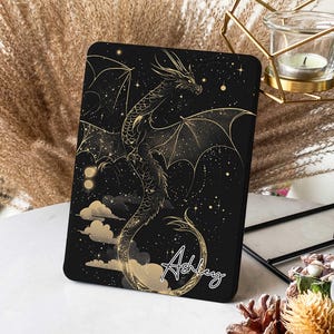 May include: Black and gold tablet case with a dragon design and the name "Ashley" written in cursive.