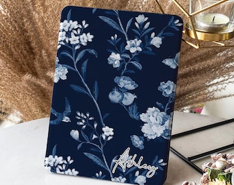 May include: A navy blue personalized iPad case with a white floral pattern and the name "Ashley" written in white script.