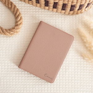 May include: A light brown leather notebook with the word "Connor" embossed on the front.