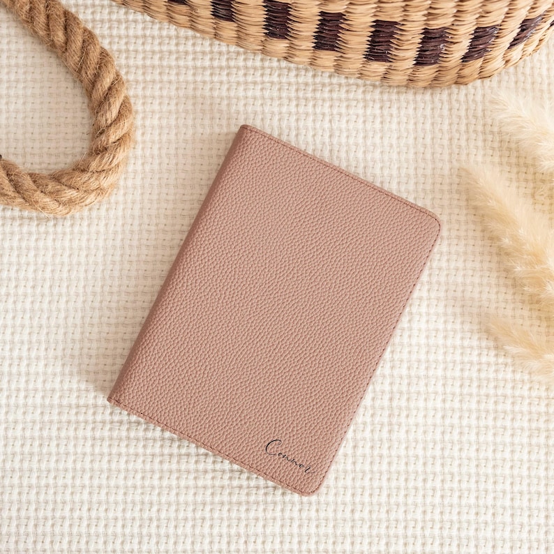 May include: A light brown leather notebook with the word "Connor" embossed on the front.