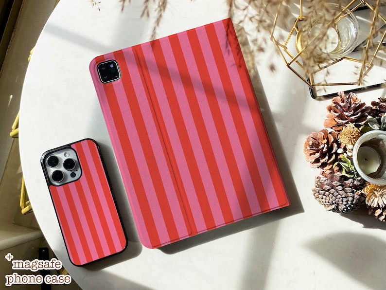May include: A smartphone case and a tablet cover featuring a vertical striped pattern in alternating shades of bright red and light pink. Both items have a smooth finish and are designed to protect mobile devices with precise cutouts for cameras.