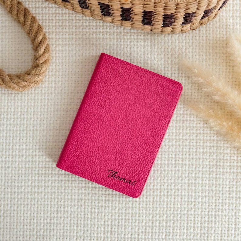 May include: A pink leather journal with the name "Thomas" embossed in black lettering.