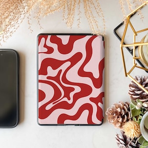May include: A pink and red abstract swirl pattern Kindle case. The case is closed and the back is visible.