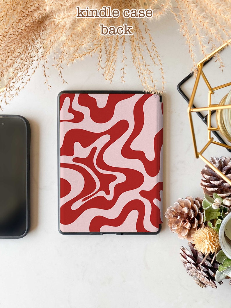 May include: A pink and red abstract swirl pattern Kindle case. The case is closed and the back is visible.