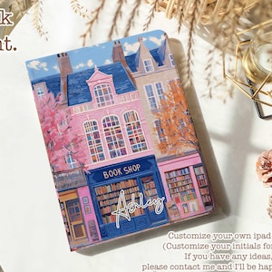 Könnte beinhalten: Ein illustrierter Buchladen in Rosa und Blau mit einem Schild, auf dem "Book Shop" steht und der Name "Ashley" in weißer Kursivschrift geschrieben ist. Der Laden ist von Bäumen und Gebäuden umgeben.