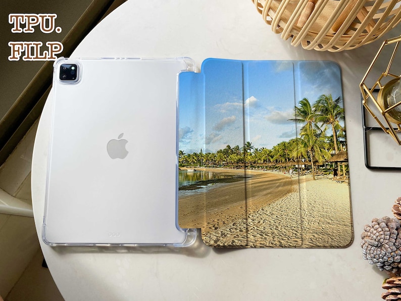 May include: A clear TPU case with a tropical beach scene printed on the back. The case is designed for an iPad or tablet and has a flip cover.