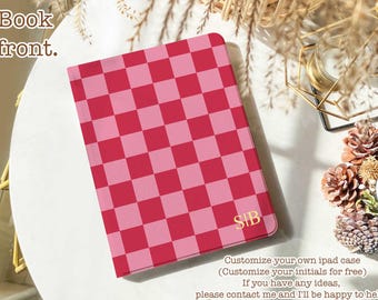 May include: Pink and red chequered iPad case with gold initials "SIB". The case is shown on a white surface with text that says "Book front."