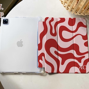 May include: A tablet case featuring a clear TPU back shell and a folding front cover with a red and light pink wavy pattern. The front cover includes the letters AC in the bottom right corner. The text TPU. FILP appears in the top left.