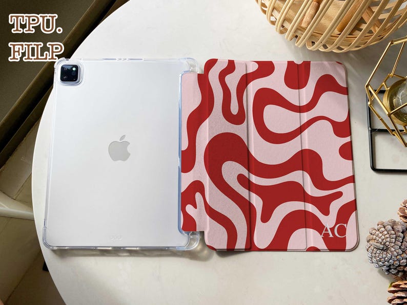 May include: A tablet case featuring a clear TPU back shell and a folding front cover with a red and light pink wavy pattern. The front cover includes the letters AC in the bottom right corner. The text TPU. FILP appears in the top left.