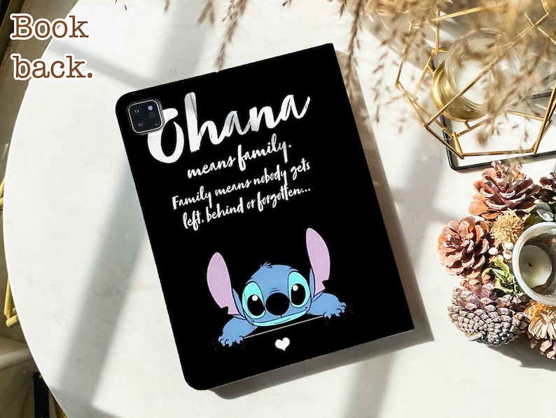 May include: Black phone case with a blue Stitch character peeking out from the bottom. The case has white text that reads "Ohana means family. Family means nobody gets left behind or forgotten..."