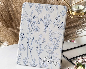 May include: A white and blue floral patterned tablet case with the name "Ashley" written in cursive on the bottom right corner.