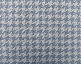 May include: A blue and white houndstooth patterned fabric. The fabric has a subtle texture.