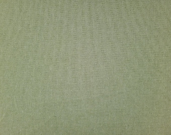May include: A close-up of a green fabric with a subtle textured pattern.