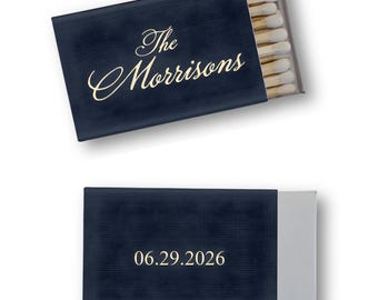 May include: Navy blue matchboxes with gold lettering. One box reads "The Morrisons" in script, the other reads "06.29.2026". The matches are visible in the open box. The boxes have a textured appearance.