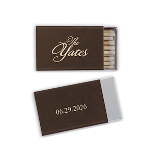 May include: Two brown matchboxes, one open and one closed, against a white background. The closed box has the text "The Yates" in gold script. The open box displays the date "06.29.2026" in a simple font.