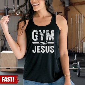 May include: A black racerback tank top featuring the white distressed text GYM and JESUS printed on the front. The garment has a scoop neckline and a sleeveless design, constructed from a solid black fabric with a clean, finished hemline.