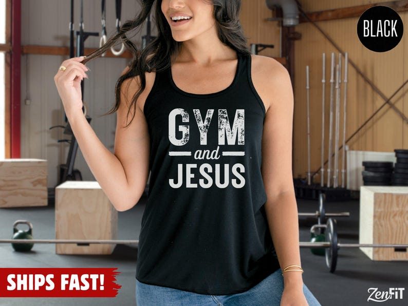 May include: A black racerback tank top featuring the white distressed text GYM and JESUS printed on the front. The garment has a scoop neckline and a sleeveless design, constructed from a solid black fabric with a clean, finished hemline.