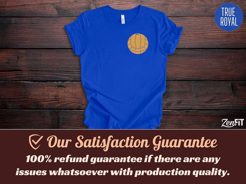 Puede incluir: Una camiseta de manga corta en color azul real con un peque&ntilde;o gr&aacute;fico centrado de un voleibol de color tostado con estilo vintage en la parte superior del pecho. La prenda tiene cuello redondo y un corte est&aacute;ndar con un dise&ntilde;o sencillo.