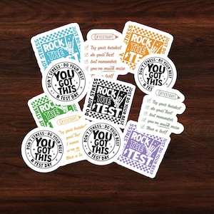 May include: A set of colorful stickers with motivational messages for test day. The stickers feature phrases like "Don't Stress - You Got This" and "Rock The Test" with a skeleton hand making a rock and roll gesture.