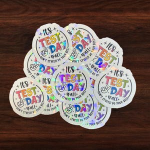 May include: A set of nine iridescent stickers with the text "It's Test Day Y'all! Don't Stress! Do Your Best." in rainbow colors.