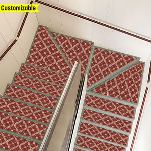 May include: Red and green patterned stair treads with a white background. The treads are installed on a carpeted staircase.