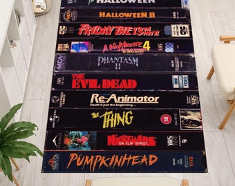 Dywan VHS, dywan z horrorem na VHS, dywan estetyczny, dywan z taśmą, dywan z kasetą, dekoracja sali kinowej, dywan z VHS na Halloween, dywan retro z VHS, dywan VHS w stylu gotyckim w sali kinowej