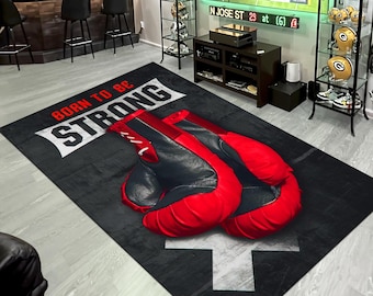 May include: A black and gray rug with a white arrow and the text "BORN TO BE STRONG". A pair of red and black boxing gloves are on the rug.