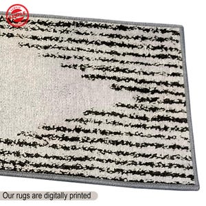 Puede incluir: Una alfombra de rayas blancas y negras con un borde gris. La alfombra tiene un dise&ntilde;o moderno y est&aacute; impresa digitalmente.