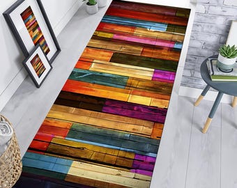 May include: A colorful, abstract runner rug with a wood plank design. The rug features a variety of colors, including red, orange, yellow, green, blue, purple, and brown. The rug is made of a soft, durable material and is perfect for adding a touch of style to any room.