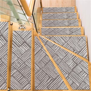 May include: A set of six grey and white patterned non-slip stair treads. The treads have a geometric design with white lines on a grey background.