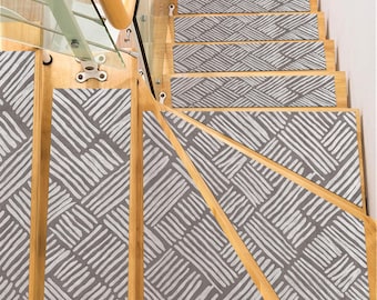 May include: A set of six gray and white patterned non-slip stair treads. The treads have a geometric design with white lines on a gray background.