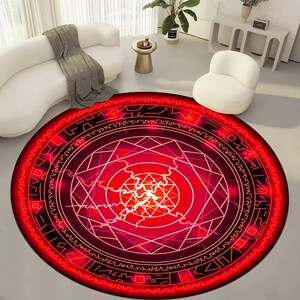 May include: Red and black round rug with a geometric pattern. The pattern features a circle with a star inside, surrounded by a series of concentric circles.