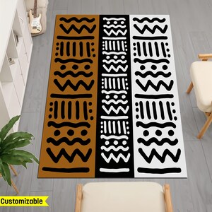May include: A brown, black, and white patterned rug with geometric shapes. The rug has a tribal design.