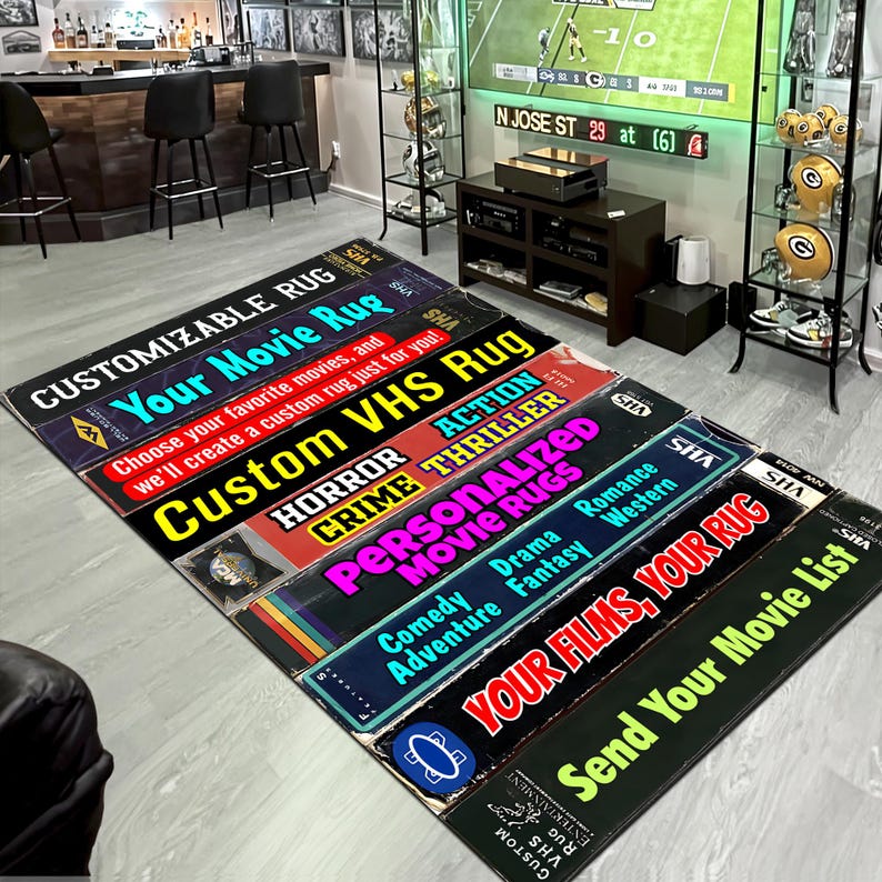 Może przedstawiać: Kolekcja prostokątnych dywan&oacute;w z motywem kasety VHS. Każdy dywan zawiera tekst, taki jak "Your Movie Rug", "Custom VHS Rug" i "Send Your Movie List". Dywany ułożone są na jasnoszarej podłodze.