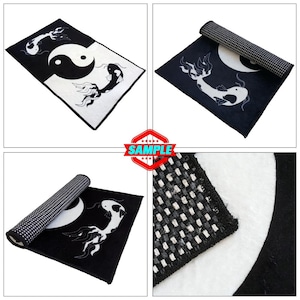 May include: Black and white rug with a yin yang symbol and two fish designs. The rug is rolled up in the image.