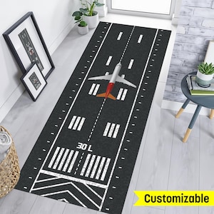 May include: A black and white airplane runway rug with a white airplane in the center. The rug has the text "30 L" printed on it. The rug is customizable.