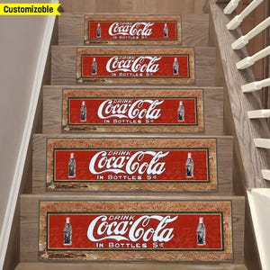 May include: Five red and white Coca-Cola stair treads with a brick pattern. Each tread features a vintage Coca-Cola logo with a bottle and the text "Drink Coca-Cola in Bottles 5¢".
