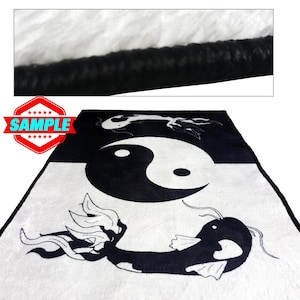 May include: Black and white plush throw blanket with a yin yang symbol and two fish designs. The blanket has a black border.
